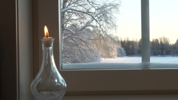 Ljus Flaska Bredvid Hemfönster Med Snöigt Landskap Utanför — Stockvideo