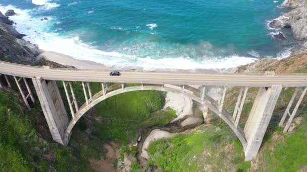 カリフォルニア州のビッグサー海岸にあるビックスビー クリーク橋 車の交差点と橋の空中ビュー — ストック動画