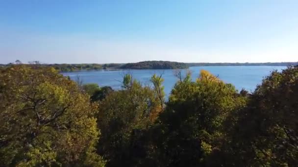 秋天的时候 一架无人驾驶飞机在明尼苏达州的瓦塞卡上空飞过树木 发现了蓝天背景下的一个湖泊和森林 — 图库视频影像