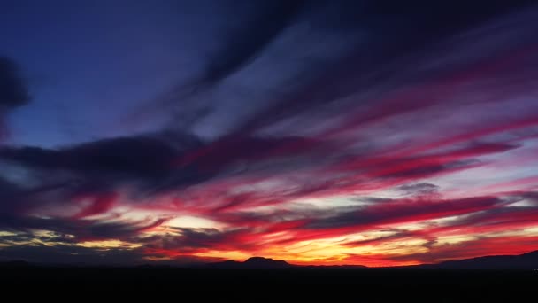 シルエットの乾燥した風景とモハーヴェ砂漠の上の見事なカラフルな夕日 空撮ビュー — ストック動画