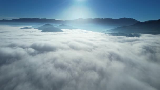 背景の山の範囲で天空の美しい晴れた雲の上を飛ぶドローンの空中ビュー日の出 — ストック動画