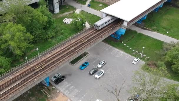 Tunnelbanetåg Kommer Från Stationen Över Cykelväg Och Parkeringsplats — Stockvideo