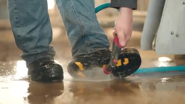 人类用高压水清洗机清洗靴子 — 图库视频影像