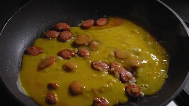 Geschlagene Eier Einer Pfanne Mit Wurststücken Und Gehackten Zwiebeln Kochei — Stockvideo