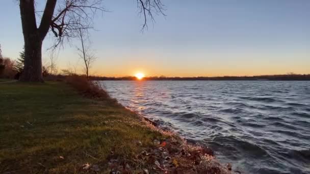 湖の岸から地平線の景色に沈む太陽 — ストック動画