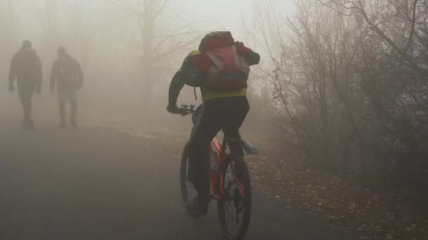 寒い冬の日には袋を持った男が濃霧の中を上り — ストック動画