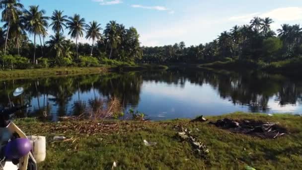 楽園熱帯の風景 バイクは湖の近くに停めた 空中飛行前進 — ストック動画