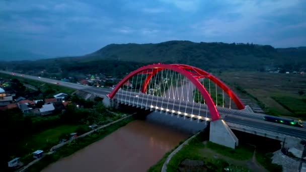 トランスジャワ有料道路 バタンの象徴的な赤い橋であるKalikuto橋の空中写真日の出 インドネシア中部ジャワ — ストック動画