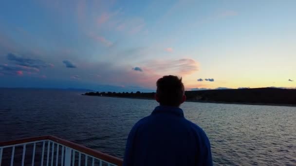 黒い茶色の髪と雲を見て青いジャケットを持つ男のバックビュー アドリア海クロアチアの地中海ヴィス島での移動フェリーの眺め — ストック動画