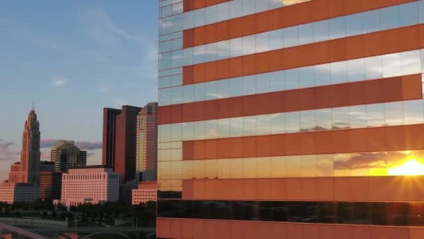 Aerial view of the sunset reflecting from windows with downtown Columbus in the background - tracking, drone shot