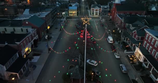 車はクリスマスの休日のライトで飾られた町をドライブします 空中プルバックはショットを明らかに — ストック動画