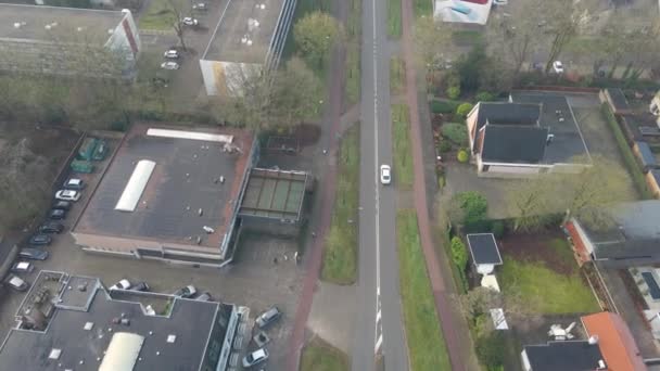 Luchtfoto Van Witte Auto Rijden Kleine Stad Weg Naast Appartementen — Stockvideo
