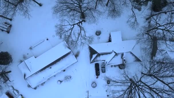 アメリカ中西部の雪に覆われた屋根の上に夕方に降下するドローン — ストック動画