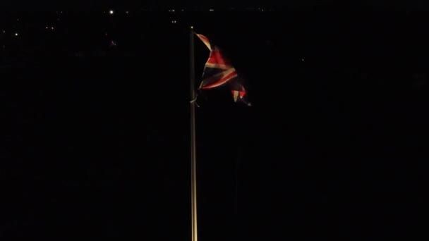 Upplyst Brittisk Union Jack Flagga Viftar Vinden Mot Natten Stadsbild — Stockvideo