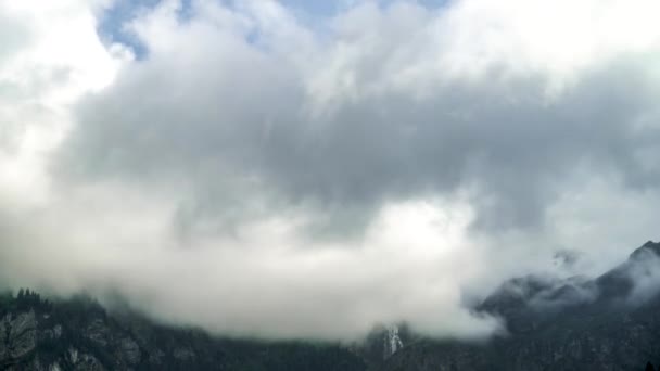 Időszakos felvétel felhőkről, amik egy hegy csúcsán mozognak az Alpokban. Ködös nap Svájcban, míg a felhők gyorsan mozognak.