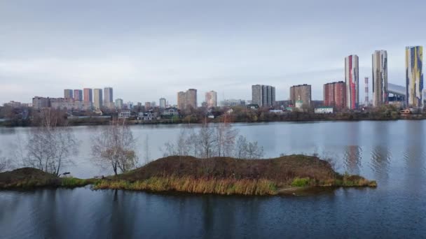 高層都市スカイラインに対する湖の間の小さな島に沿ってフライト — ストック動画