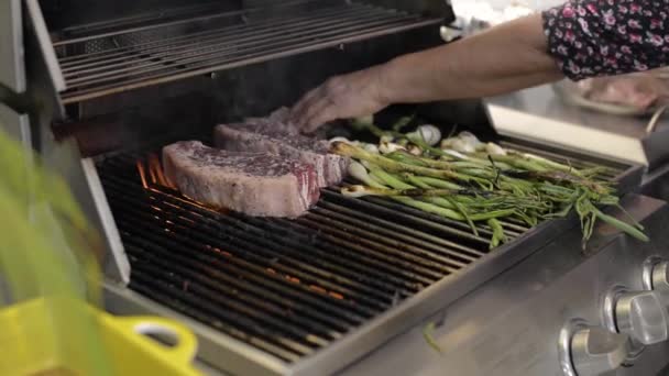两个纽约的牛排放在烤架上 一边用葱煮 — 图库视频影像