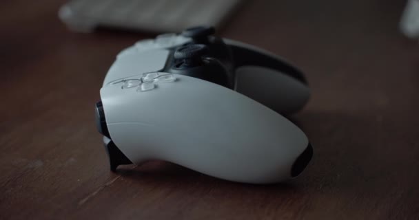 Белый Черный Игровой Контроллер Сидит Коричневом Столе Замедленной Съемке — стоковое видео