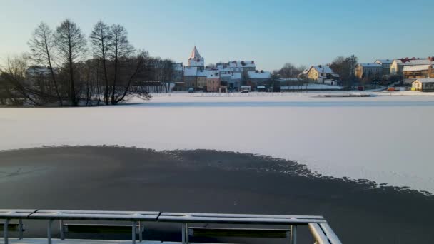 冷たい雪の街の足跡が凍る湖の上の雪の橋 — ストック動画