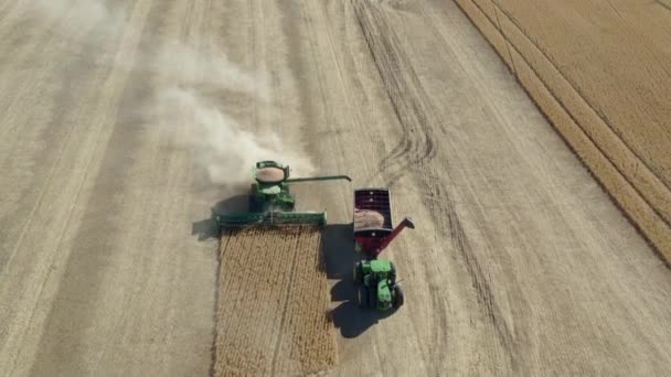 在加拿大萨斯喀彻温省农场收获庄稼的拖拉机的空中视图 — 图库视频影像