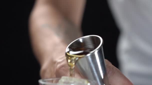 调酒师用深褐色的酒在冰块上倒入高脚杯 动作缓慢 — 图库视频影像