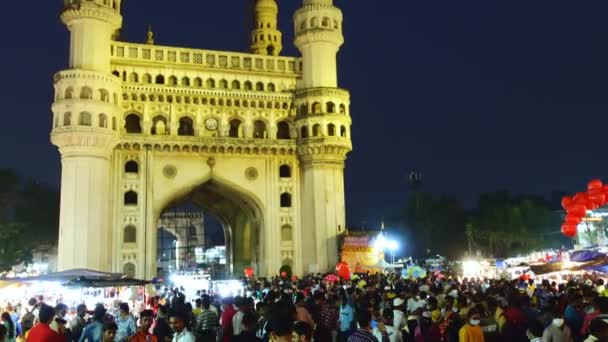 하이데라바드에서 저녁에 열리는 미나르 기념비 앞에서 물품을 번잡하고 붐비는 시장의 — 비디오