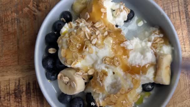 Äter Frukost Med Blåbär Banan Yoghurt Och Havre Med Lite — Stockvideo