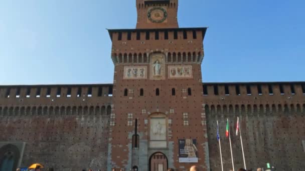 イタリア ミラノの時計塔をバックに ミラノのスフォルツァ城を歩く人々の傾き — ストック動画
