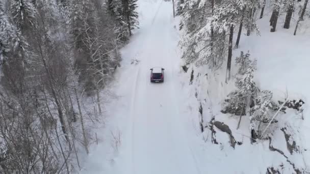 Luftaufnahme Vom Autofahren Auf Der Verschneiten Straße Durch Den Wald — Stockvideo