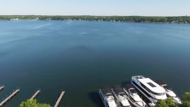 大きなボートと穏やかな水 空中ドローンビューを持つ湖港 — ストック動画