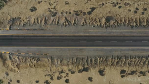Воздушный Взгляд Вниз Автомобиль Проходит Пустой Дороге Через Пустынный Ландшафт — стоковое видео