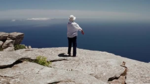 女性の練習気功キクラデス諸島の青い海の前で ギリシャ 昼間の無人機で撮影 朝の太極拳に最適な場所 — ストック動画