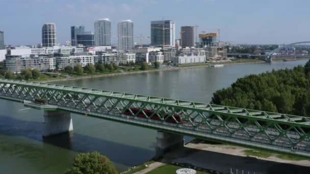 ブラチスラバ スロバキア 日当たりの良い夏の緑の古い橋の上に運転する赤いトラムの空中ショット — ストック動画