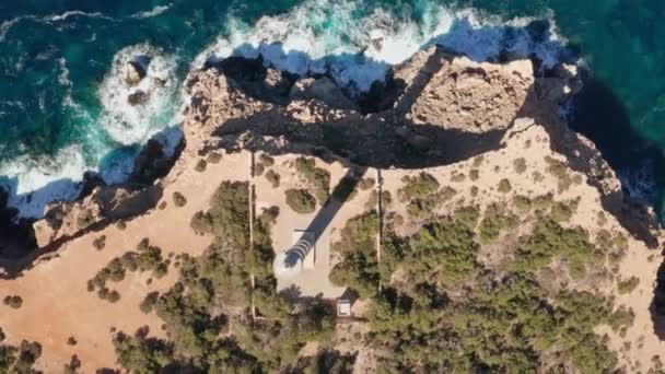 スペイン イビサ島のプンタ モスカーター灯台の空中トップダウンビュー 灯台と澄んだ海と空 崖に打ち寄せる波 — ストック動画