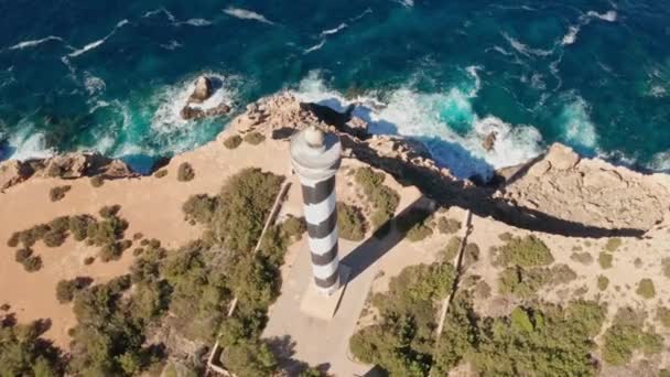 在西班牙Ibiza的Punta Moscarter灯塔上 可以看到空中的美景 把灯塔拉近 露出清澈的大海和天空 汹涌的波浪拍打着悬崖 — 图库视频影像
