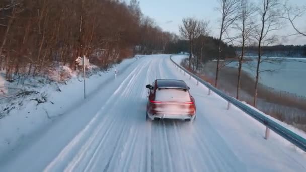 Orange Porsche Macan Gts 2022 Gölün Kenarındaki Karlı Yolda Takip — Stok video