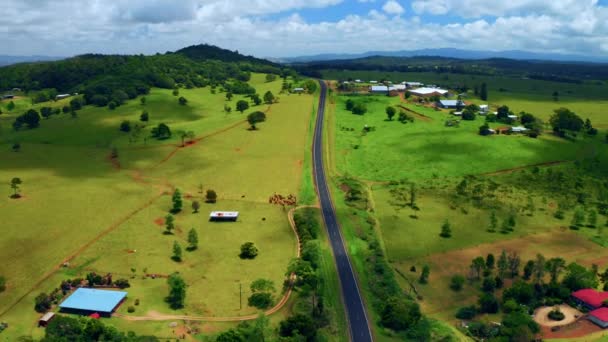 オーストラリアのクイーンズランド州のテーブルランド地域のアサートンの農村部の緑豊かなフィールドの風景の空中ビュー パンニングを下げて — ストック動画