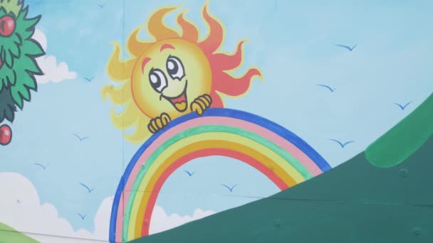 Zbliżenie Malowidła Dla Dzieci Plac Zabaw Uśmiechnięte Słońce Tęczą — Wideo stockowe