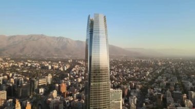Andes Dağları arkasındayken Gran Torre Santiago 'nun hava görüntüsü. Dolly In