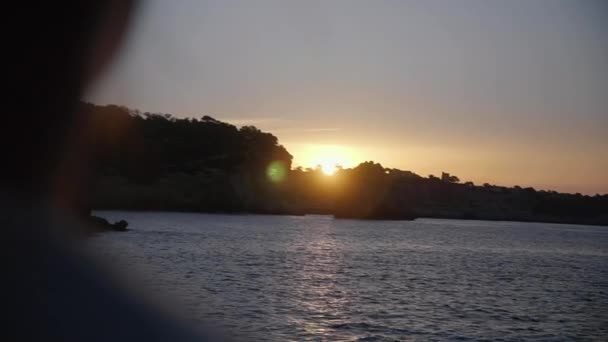 一个年轻女子的背影站在悬崖上 看着美丽的日出在马略卡岛的海岸线 — 图库视频影像