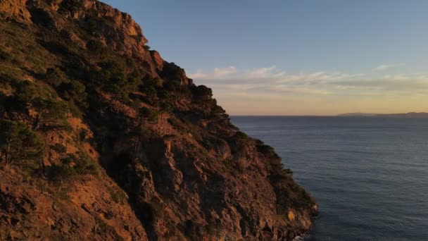Nagranie Drona Oświetlonego Słońcem Postrzępionego Nadmorskiego Klifu Wzdłuż Wybrzeża Morza — Wideo stockowe
