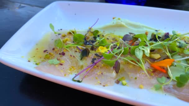 伝統的なペルーのセビチ料理 アボカドソースと柑橘類のジュースで硬化新鮮な生魚 マイクログリーンとピスタチオ Kショット — ストック動画