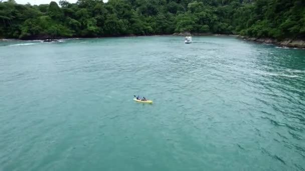 Aerial Truck Left People Kayaking Boat Turquoise Sea Dense Green — Stock Video