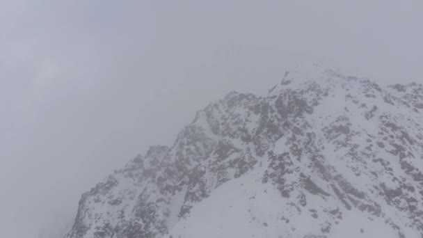 Bir Kar Fırtınası Içindeki Dramatik Kayalık Dağların Hava Görüntüsü Yörünge — Stok video