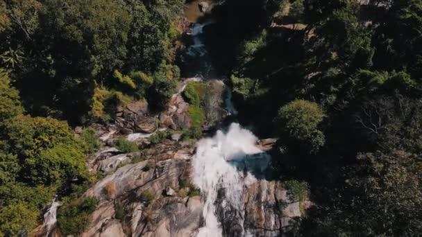 ワシラタンの滝からの水は タイの緑の自然との間の分割された岩の上に大きな高さから落ちる トップダウン台座のショット — ストック動画