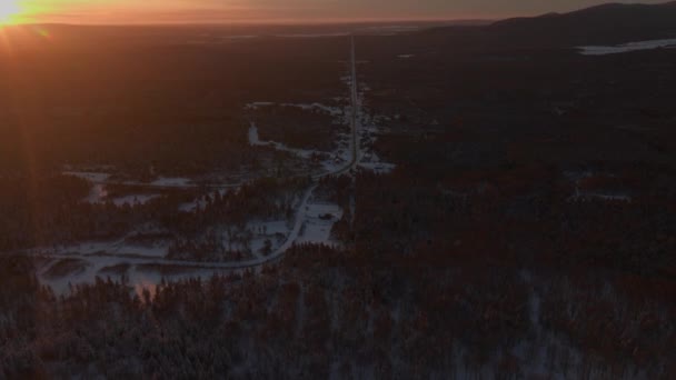 カナダ ケベック州南部の雪に覆われた道路と森の日没 空撮ドローン撮影 — ストック動画