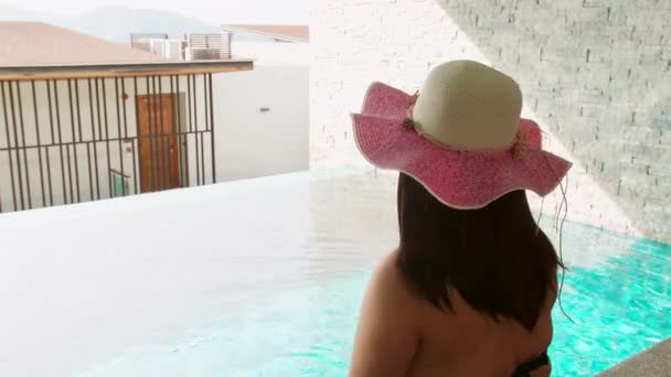 Vista Trasera Una Mujer Irreconocible Sentada Borde Piscina Con Sombrero — Vídeos de Stock