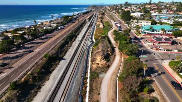 カリフォルニア州エンシニタスのカーディフ シー海岸に沿って101号線と列車の線路上でスローモーションが撮影されました — ストック動画