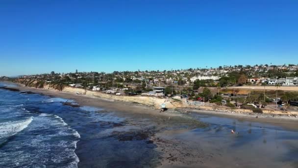 美国加利福尼亚州圣地亚哥北部101号公路沿线的一个沿海城镇 海滨波涛中的加的夫的空中后向飞行景观 — 图库视频影像
