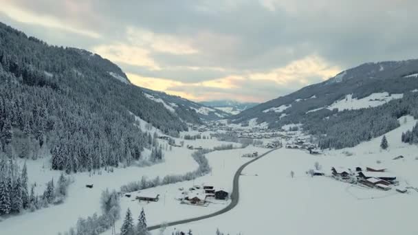 Zdjęcie Lotnicze Pokrytego Śniegiem Górskiego Miasteczka Kręta Droga Przez Dolinę — Wideo stockowe
